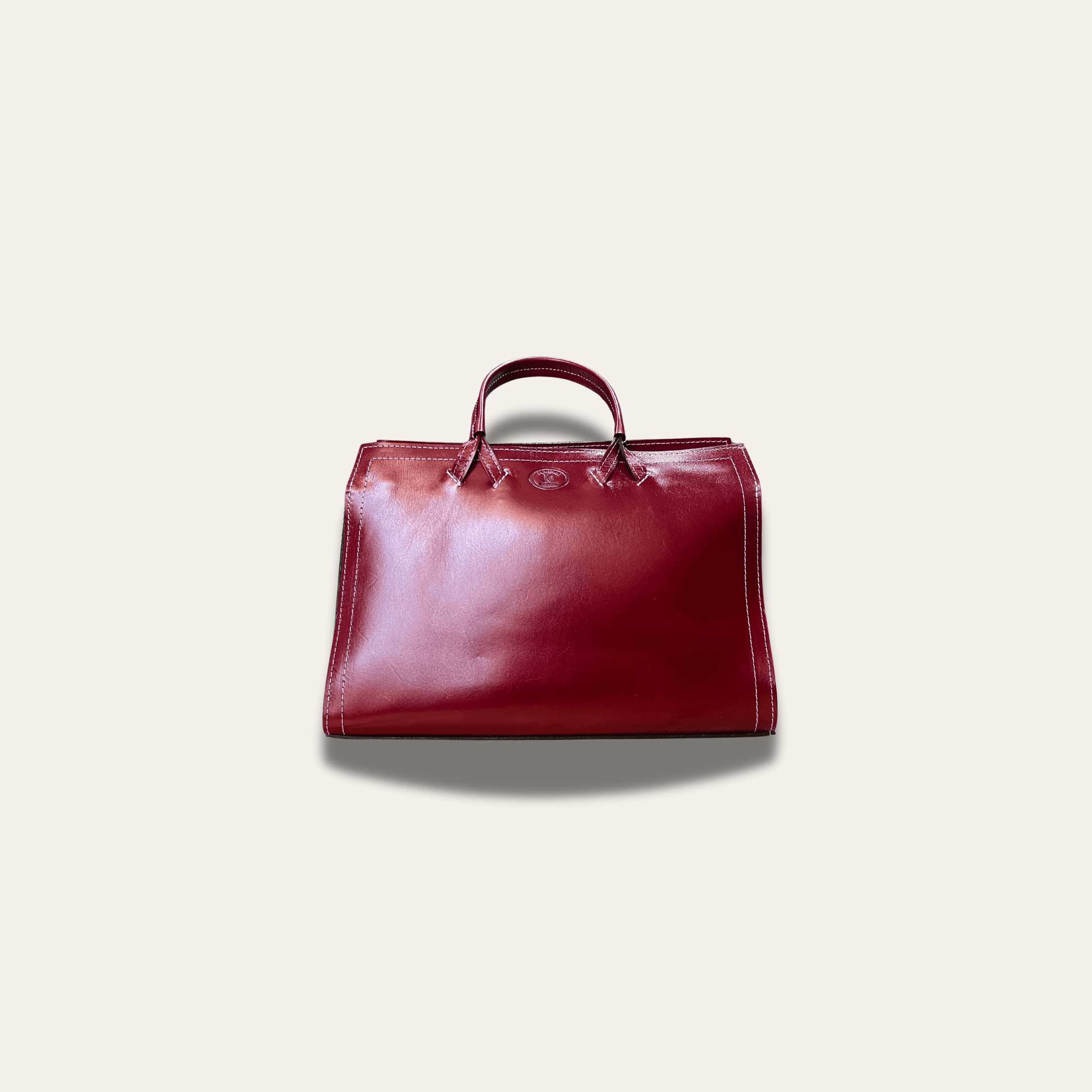 Athens Red leather bag, handcrafted since 1918, showcasing a rich, deep red hue and elegant design.