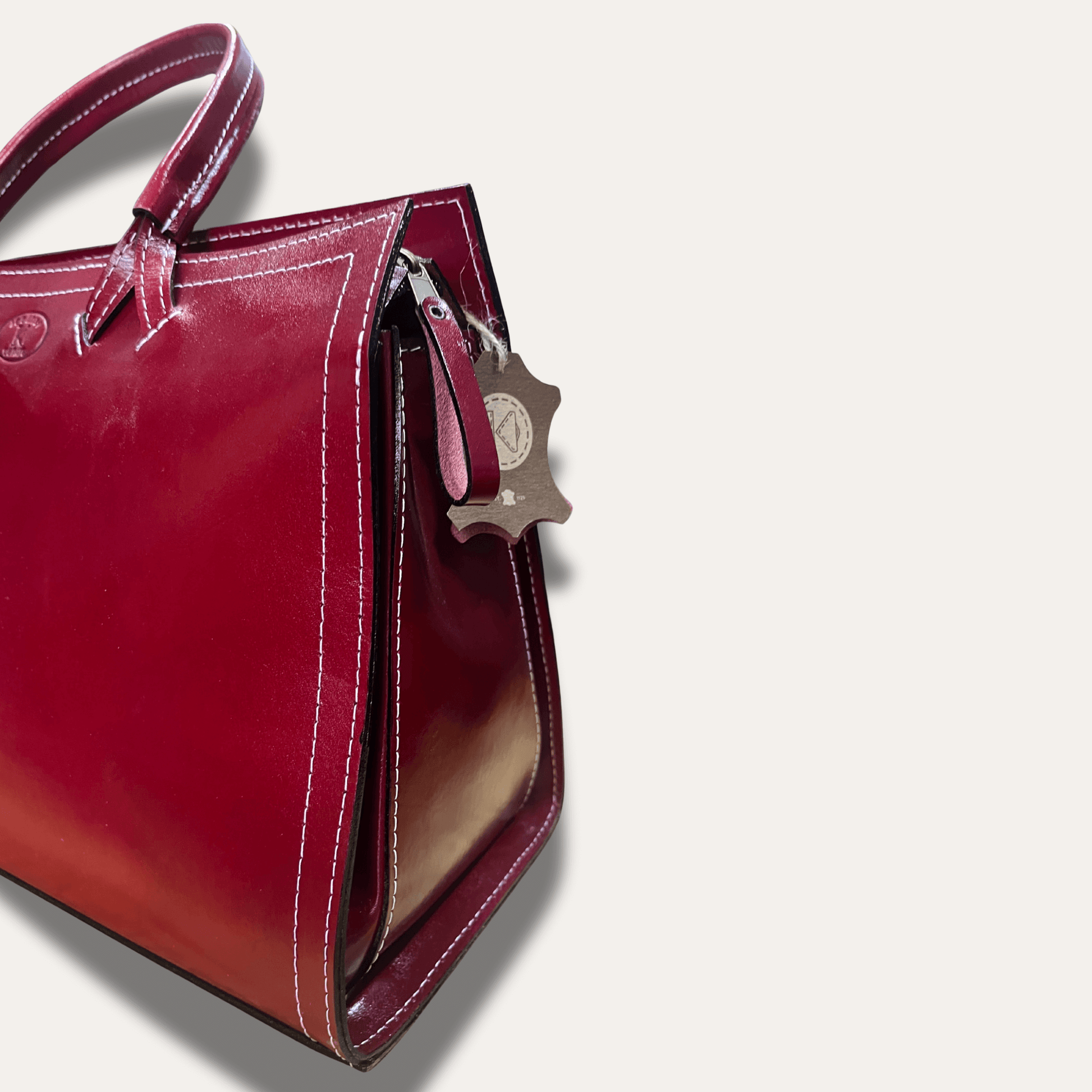 Athens Red leather handbag, handcrafted since 1918, showcasing premium quality and elegant design.